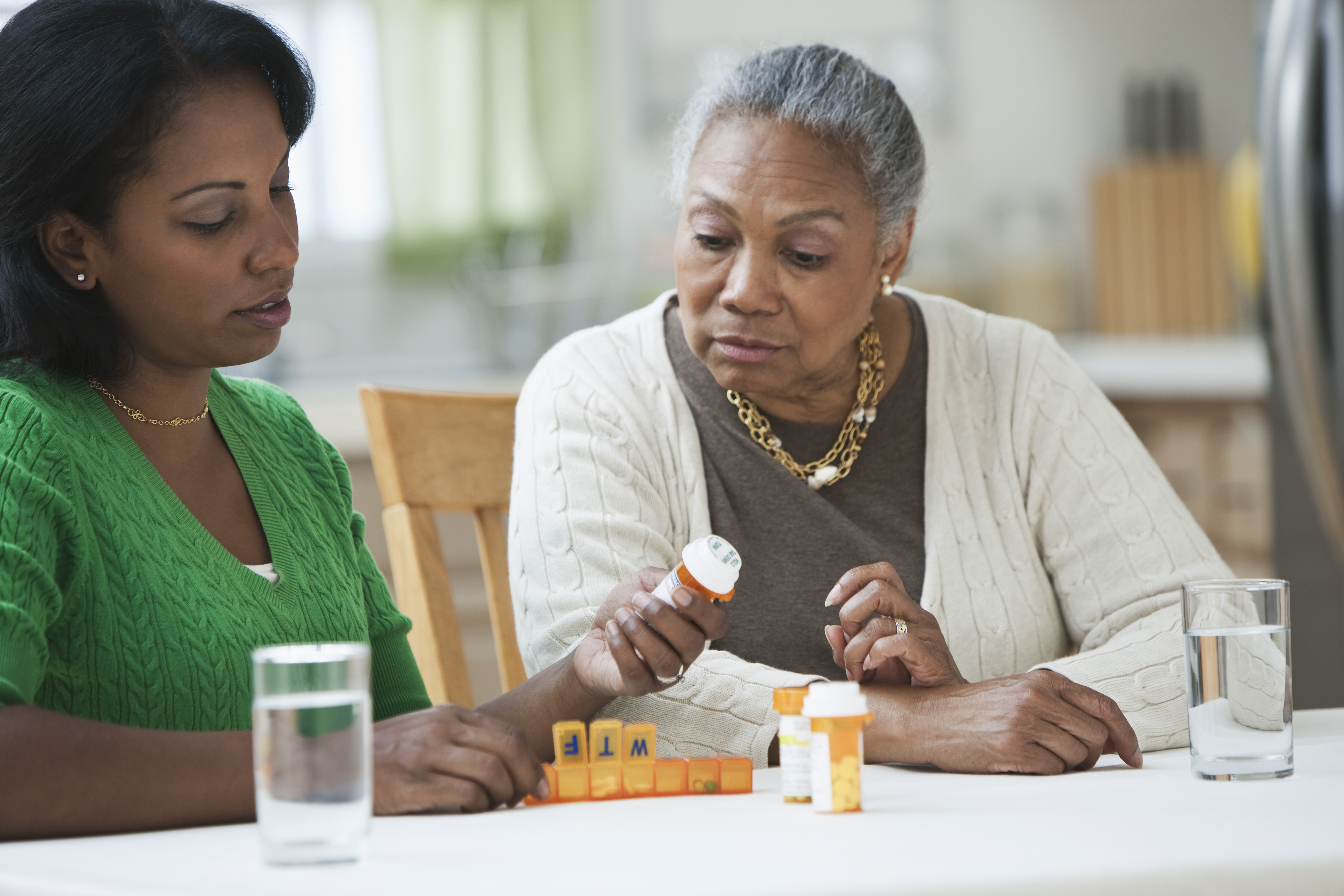 Two women looking at pill bottles